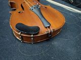 a violin sitting on the floor next to a pair of shoes