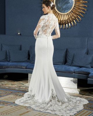 a woman in a wedding dress standing in front of a mirror