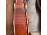 a violin sitting on top of a wooden table next to a chair
