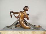 bronze statue of a woman sitting on a marble base