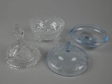 three clear glass dishes and a glass bowl on a white surface