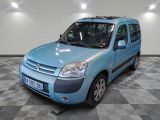 une petite camionnette bleue garée dans une pièce au sol à carreaux