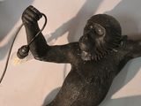 a statue of a monkey holding a hair dryer in its hand