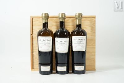 trois bouteilles de vin dans un coffret en bois sur une surface blanche