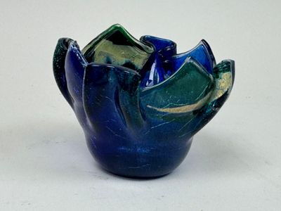 un vase bleu contenant une fleur verte