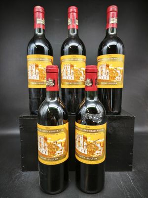 quatre bouteilles de vin rouge dans une caisse en bois sur fond noir