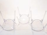 four clear glasses sitting next to each other on a white surface