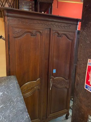 une armoire en bois avec un plateau en marbre dans une pièce