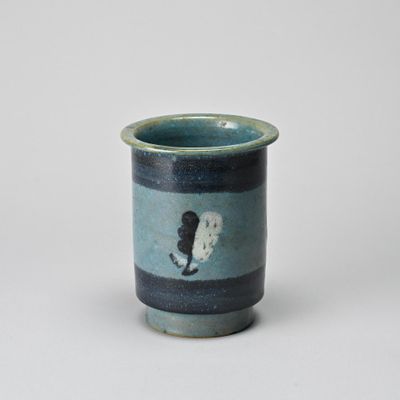 a small cup with a cat on it on a table