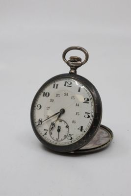 a silver pocket watch sitting on top of a white table