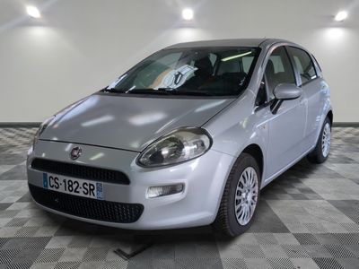 la petite voiture argentée est garée sur un carrelage à carreaux