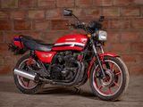 a red and black motorcycle parked in front of a brick wall