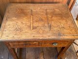 a small wooden table with a drawer on it
