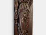 bronze sculpture of a woman holding a bird on a wooden plaque
