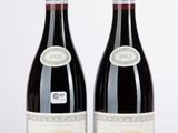 deux bouteilles de vin rouge posées l'une à côté de l'autre sur une table