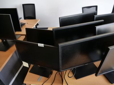de nombreux écrans d'ordinateur posés sur les bureaux de cette pièce