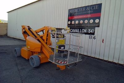 a picture of a small orange scissor parked in front of a building