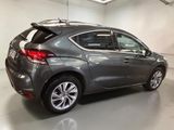 the rear end of a grey car in a garage