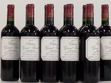 six bouteilles de vin rouge alignées sur une surface blanche