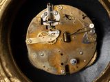 a gold clock with a black face on a table