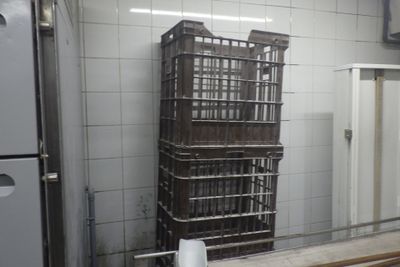 a stack of crates sitting in a kitchen next to a refrigerator