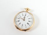 a gold pocket watch with roman numerals on the face