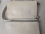 a white purse and a cell phone sitting on a table