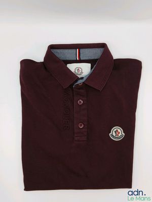 un gros plan sur un polo orné d'un écusson
