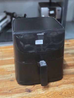 a black box sitting on a wooden table in a kitchen