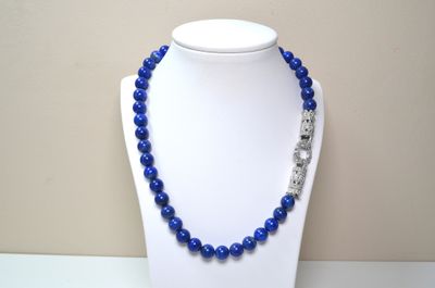 a close up of a necklace on a mannequin with blue beads