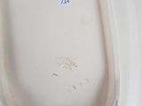underside view of a white porcelain urinal with a blue label on it