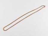 un collier en or avec une chaîne sur fond blanc