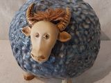 un mouton en céramique bleue et blanche avec des cornes sur la tête