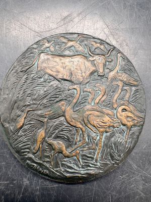 an image of a metal plate with a picture of a deer and flamingos on it