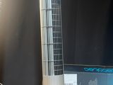 un ventilateur posé sur un bureau à côté d'un ordinateur