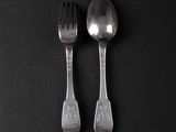 two spoons and a fork on a black surface