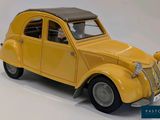 a yellow toy car that is sitting on a white surface