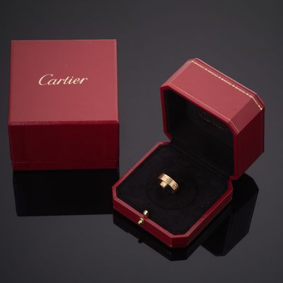 un gros plan sur une boîte rouge contenant une bague en or