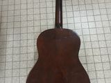 an old guitar sitting on a tiled floor in a room