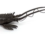 a metal sculpture of a lobster on a white surface