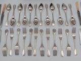 many forks and spoons laid out on the table