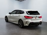 the rear end of a white bmw car in a showroom