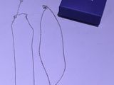 deux colliers et une boîte posés sur une table