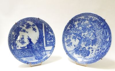 pair of blue and white plates with figures on them on a table