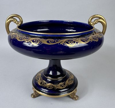 a blue vase with gold decoration on it on a stand