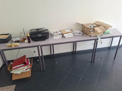 une table sur laquelle se trouvent une imprimante et des boîtes, dans une pièce