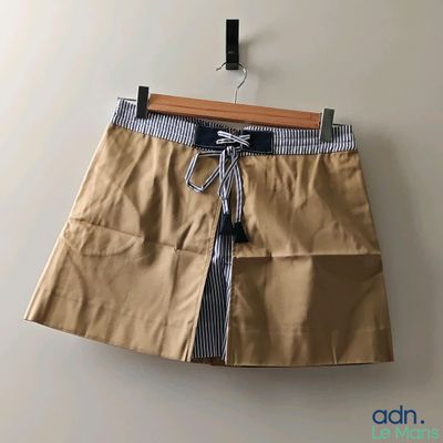 une photo d'une jupe beige accrochée à un mur