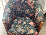 a chair with a floral upholstered seat and wooden legs