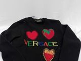 black sweater with red and green hearts and the word versa written on it