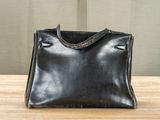 a black purse sitting on top of a wooden table